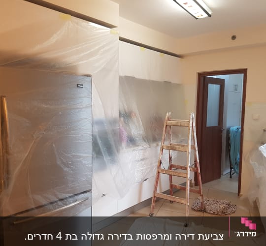 סולם ויריעות פלסטיק לכיסוי לפני צביעה במטבח